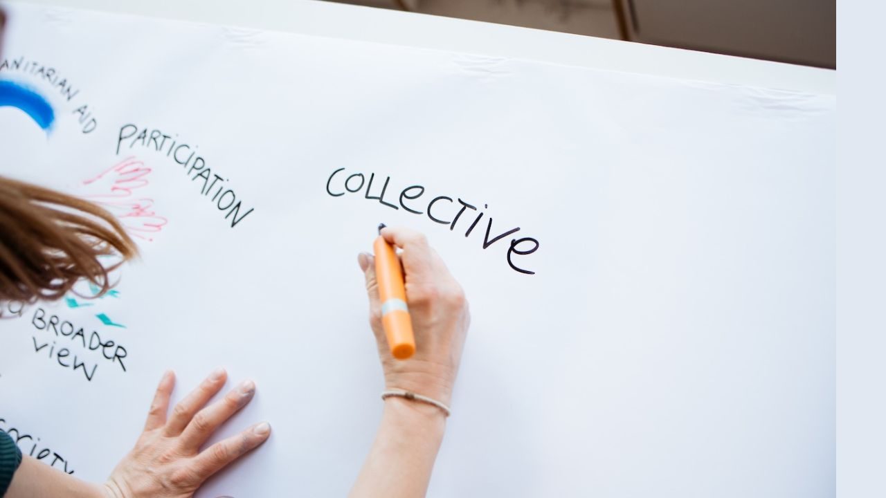 Eine rechte Hand hält einen dicken Stift, als Schrift ist zu lesen "Collective"